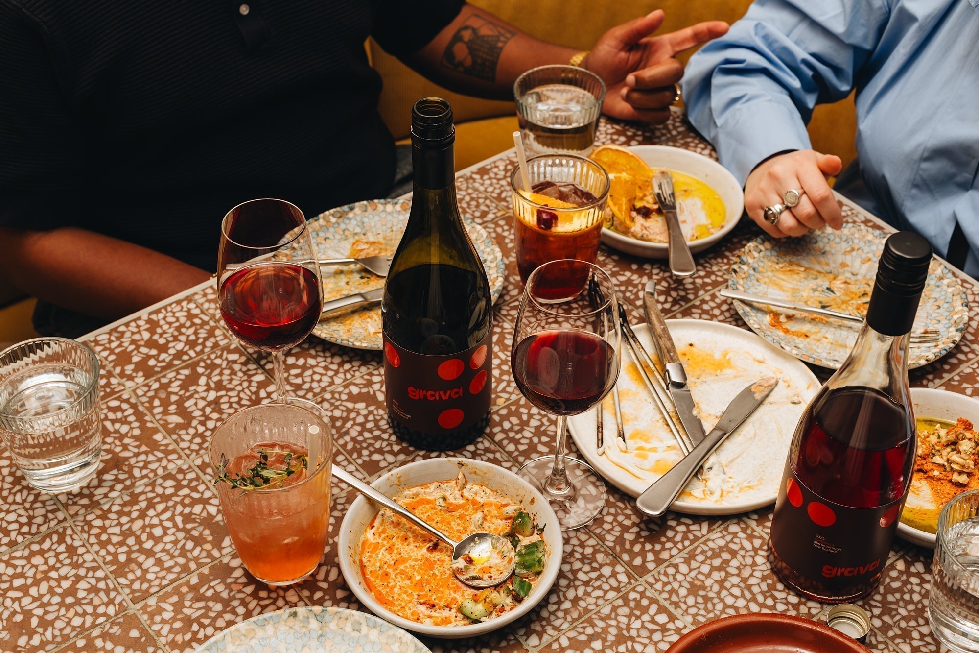 Friends sharing Grava red wine over dinner at a restaurant table