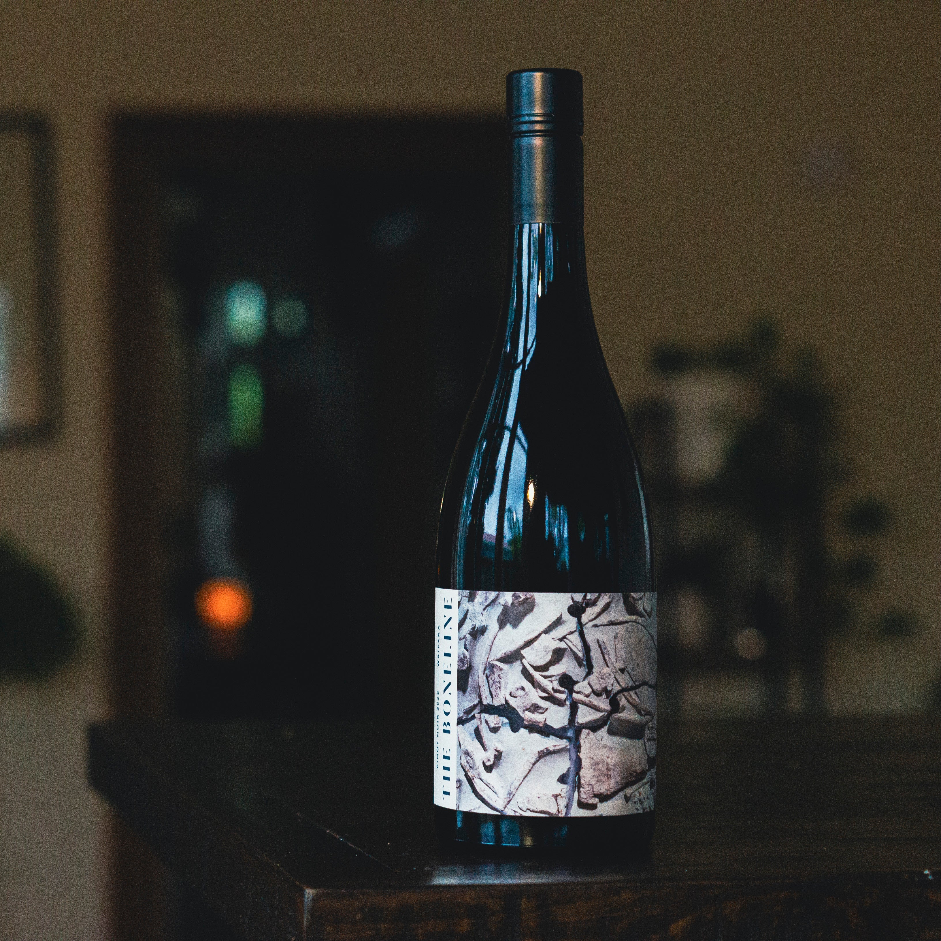 Wine bottle with a decorative label on a blurred indoor background