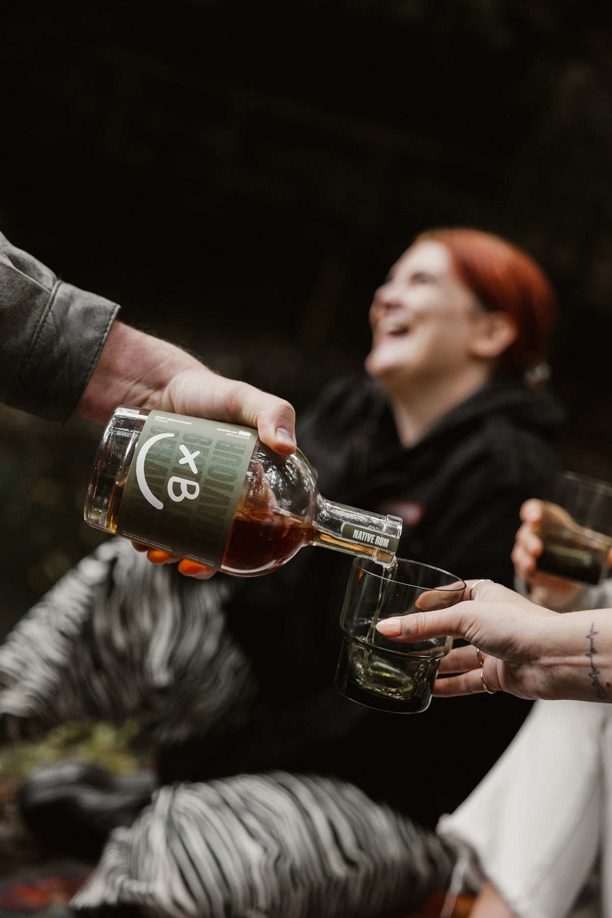 Best Behaviour Native Botanical Rum poured over ice with fresh botanicals — Kawakawa, Harakeke and Karamū
