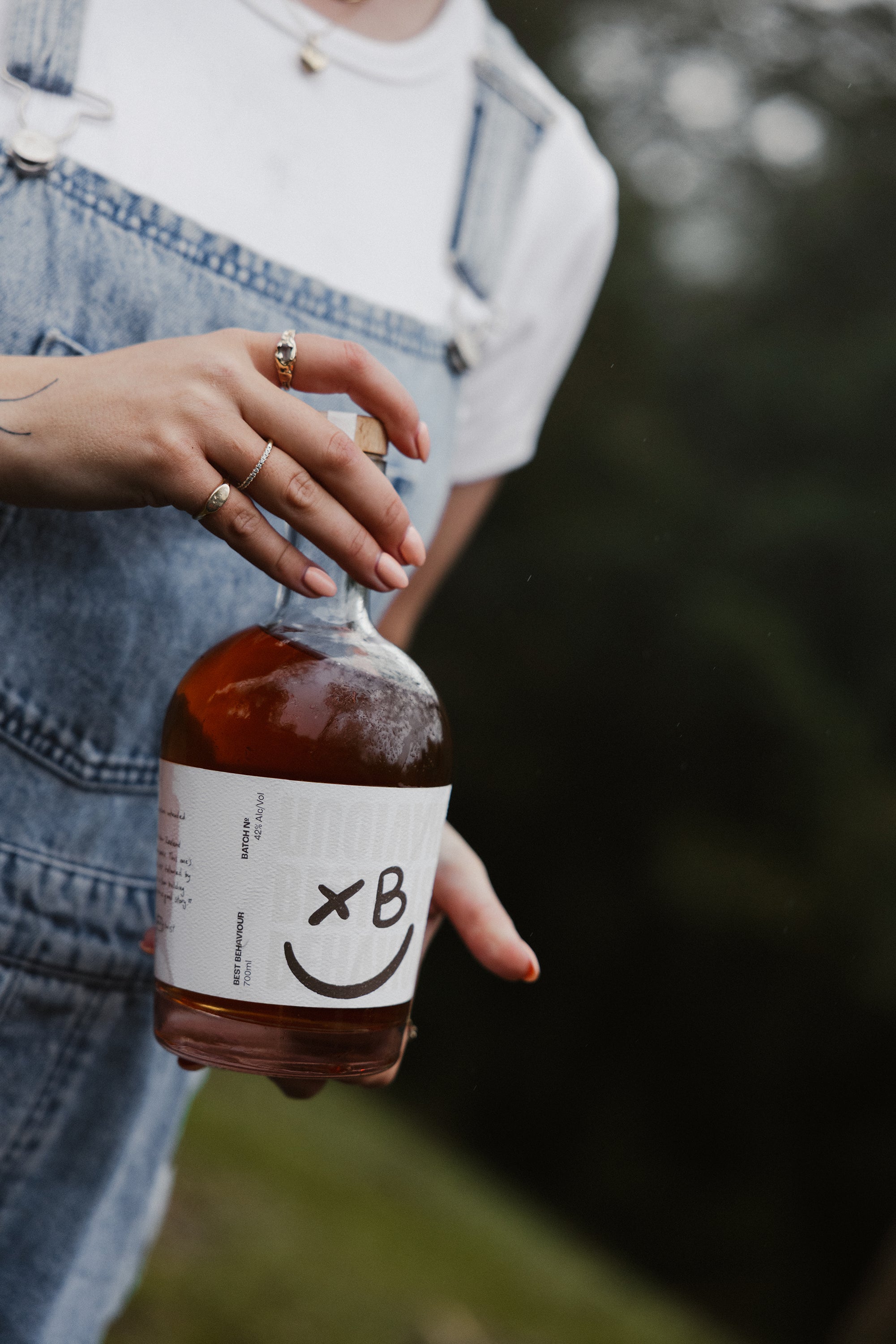 Best Behaviour Manuka Smoked Rum served over ice with mānuka honey — rich, smoky, award-winning New Zealand rum